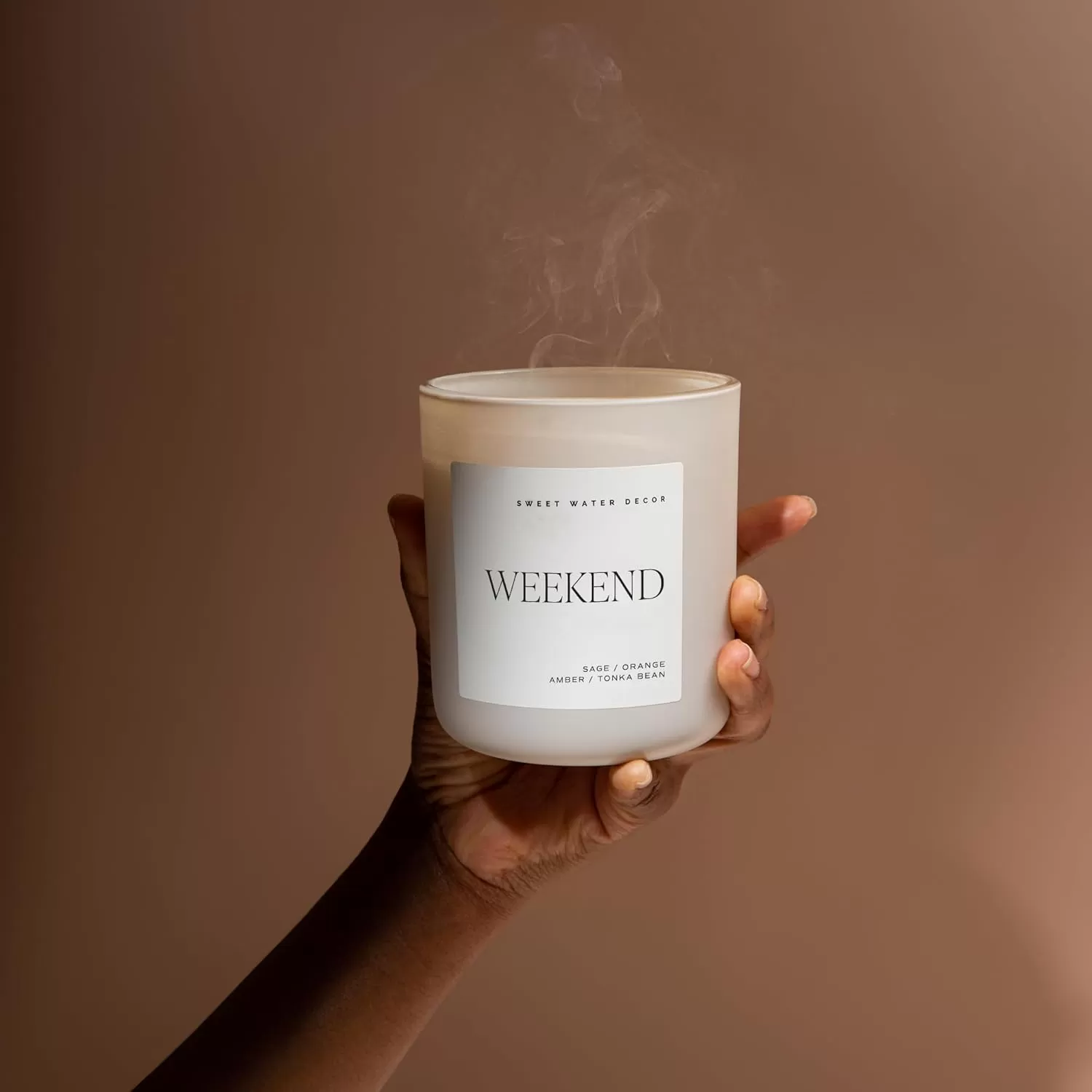 imageSweet Water Decor By The Fireside Candle  Vanilla Caramel Amber Tonka Smoky Woods Musk Winter Scented Soy Candles for Home  15oz Tan Jar 70 Hour Burn Time Made in the USATan