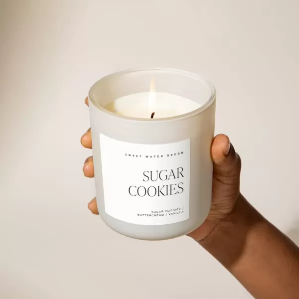 imageSweet Water Decor By The Fireside Candle  Vanilla Caramel Amber Tonka Smoky Woods Musk Winter Scented Soy Candles for Home  15oz Tan Jar 70 Hour Burn Time Made in the USATan