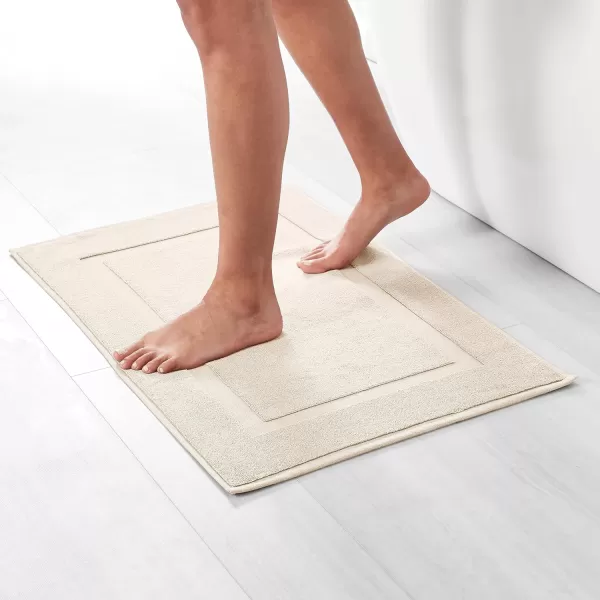 imageAmazon Basics Absorbent Cotton Machine Washable Bath Rug Mat for Shower Bright White 31quot L x 20quot WCream